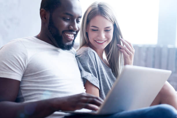 istock Peaceful young international couple using gadget at home 810556614