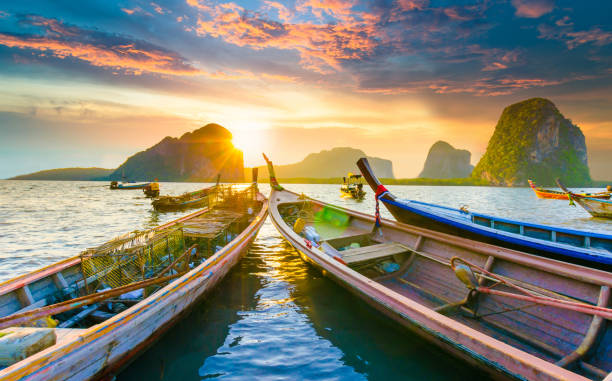 hermosa puesta de sol en el mar tropical con larga cola en bote en el sur de tailandia - nautical vessel sky andaman sea beach fotografías e imágenes de stock