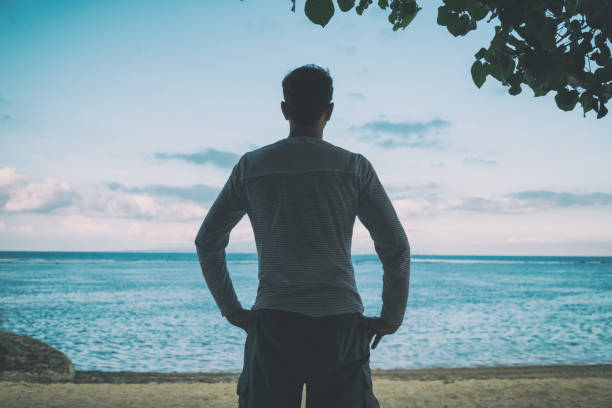 istock Young man enjoying the view on the tropical beach. 810563662