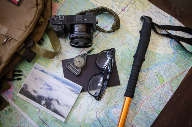 istock Hiking accessories set on wooden background with bag camera postcard glasses compass 810564018