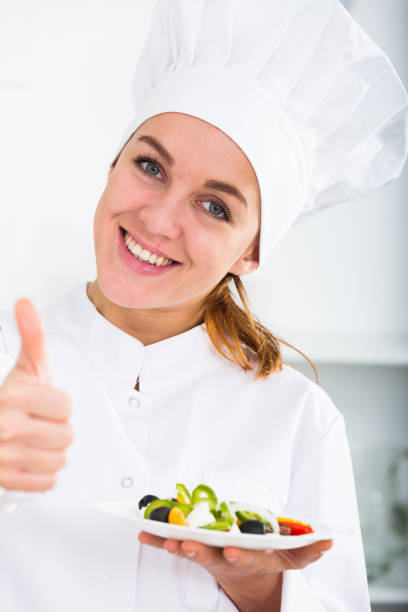 ritratto di giovane donna coosie mostrando insalata in cucina - coosie foto e immagini stock