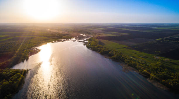 istock Aerial: Flying over a lake with sun illuminating the water. 810567248