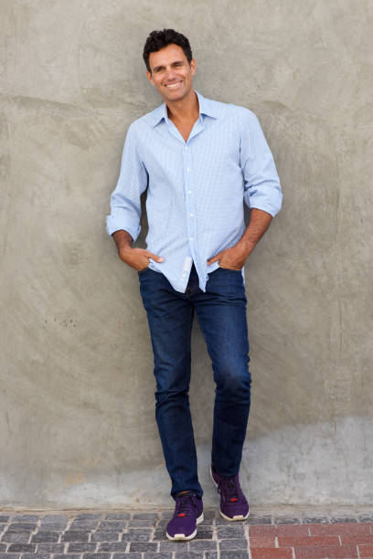 istock Full length middle age man smiling and leaning against wall 810567306