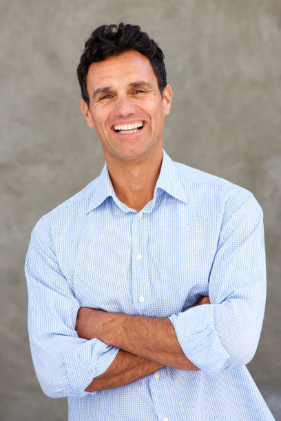 istock handsome mature man smiling with arms crossed 810567338