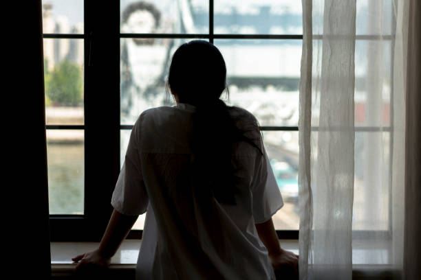 istock girl viewing cityscape through window 810567352