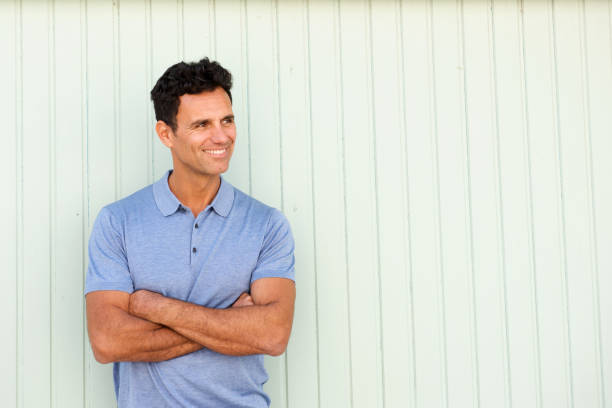 istock cool older man smiling with arms crossed 810599104