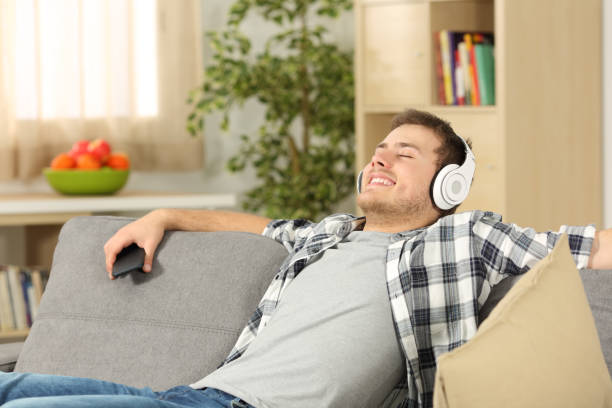istock Relaxed man listening music at home 810599430