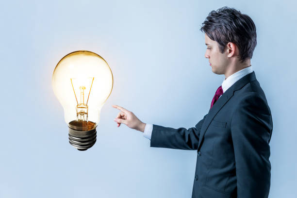 ビジネスマンの電球を指して良いアイデア コンセプトを取得 - sensory perception flash ストックフォトと画像