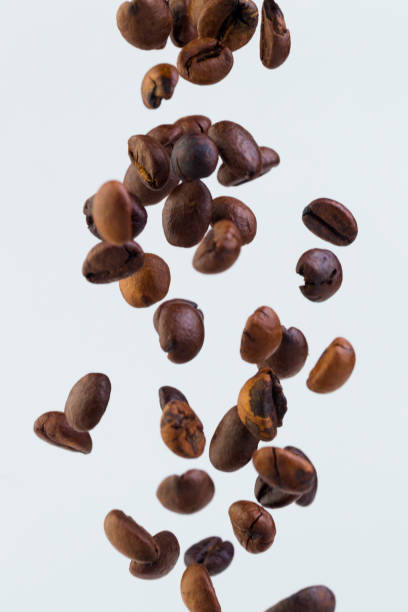 istock Falling grains of roasted coffee on a white background 810634224