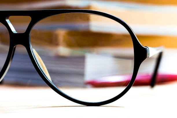 istock Glasses and book on wooden table. 810641438