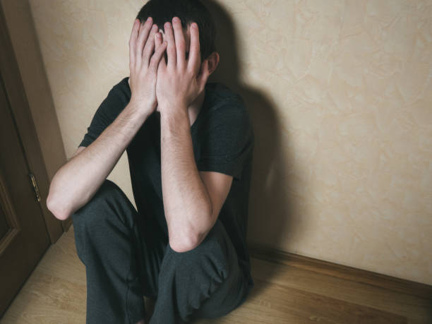 istock a young man sits on the floor. depression 810657568