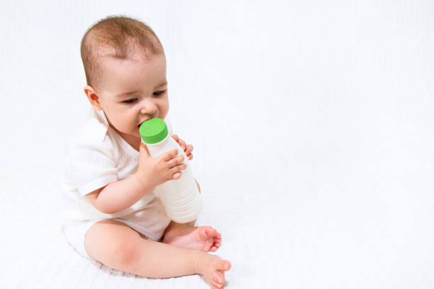 istock Beautiful infant child baby with bottle on a white background 810664416