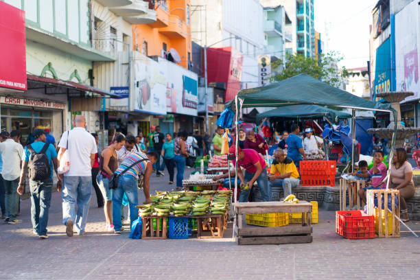 Open street market on edge of Casco Viejo an old part of Panama City. Panama City, Panama - February 16, 2017:People are walking on main shopping and promenade street along Avenida Central to Via Espania in Casco Viejo an old historic part of Panama City. On sides are authentic shopping and fast food eating kiosks with local food. place where locals go. In surrounding buildings are cheap department stores, local shops, cheap food and places selling inexpensive goods.

 panama city panama stock pictures, royalty-free photos & images