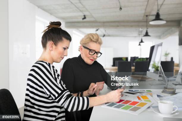 Senior And Young Interior Designers Using A Digital Tablet In The Office Stock Photo - Download Image Now