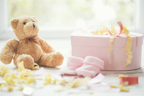 Baby shower party gifts for baby girl, teddy bear, party hat, confetti and gifts.
