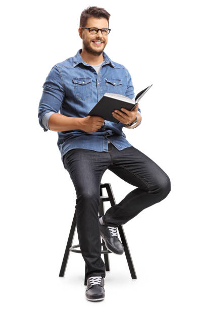 istock Man with a book sitting on a chair 810692846