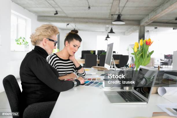 Senior Businesswoman Working Together With Young Woman In The Office Stock Photo - Download Image Now