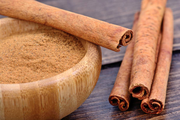 istock Cinnamon powder in a bowl and sticks on table 810701328