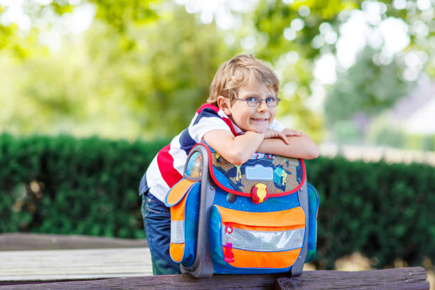 маленький мальчик с школьной сумочкой в первый день в школу - glasses child little boys happiness стоковые фото и изображения