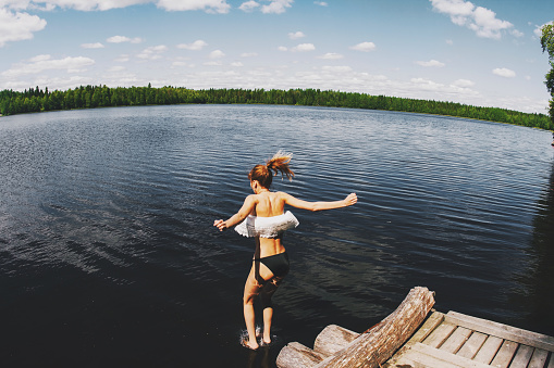 Girl diving into the lake. Back view. Copy space.
