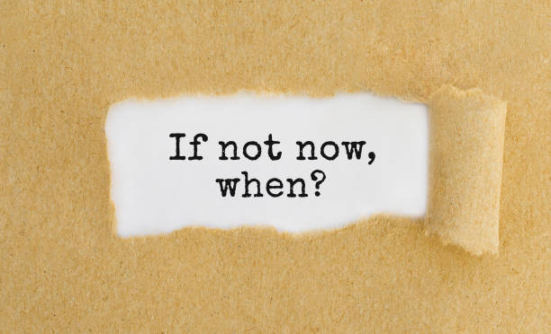 istock Text If not now, when appearing behind ripped brown paper 810721606