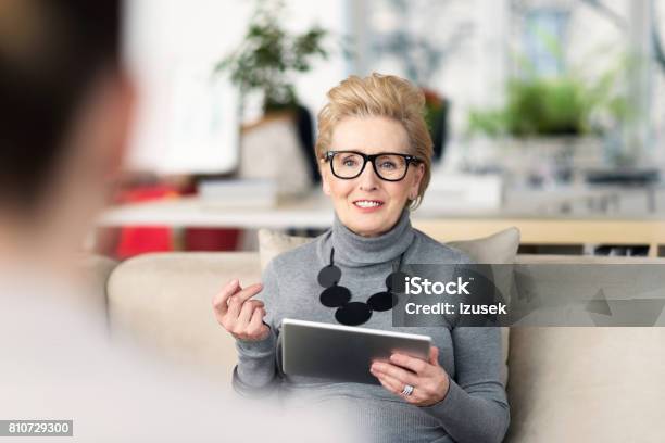 Senior Adviser Talking With Young Woman Stock Photo - Download Image Now - Digital Tablet, Mental Health Professional, Physical Therapist