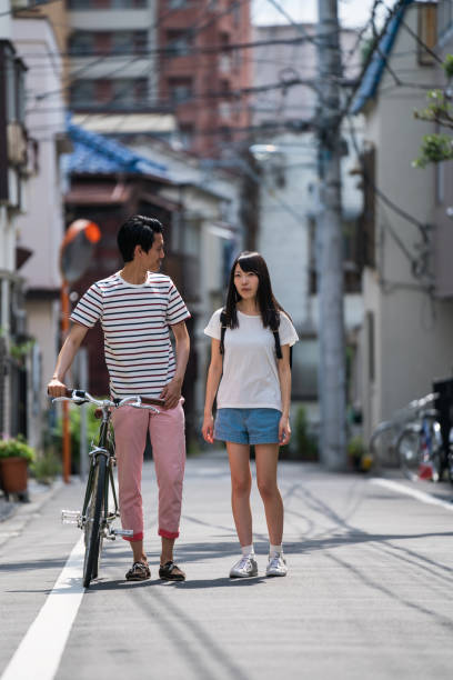 istock Man walking with a woman and pushing his bicycle 810737244