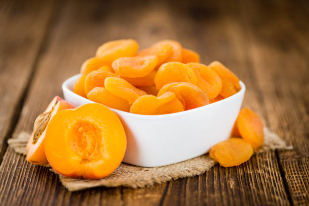 istock Apricots (dried) on wooden background (selective focus) 810747164