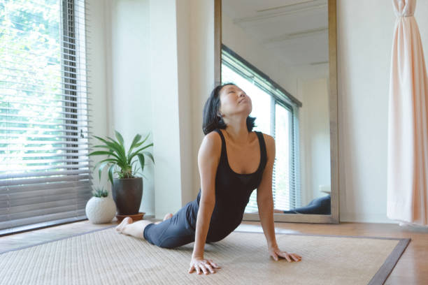 istock Asian woman practicing yoga at home 810754116