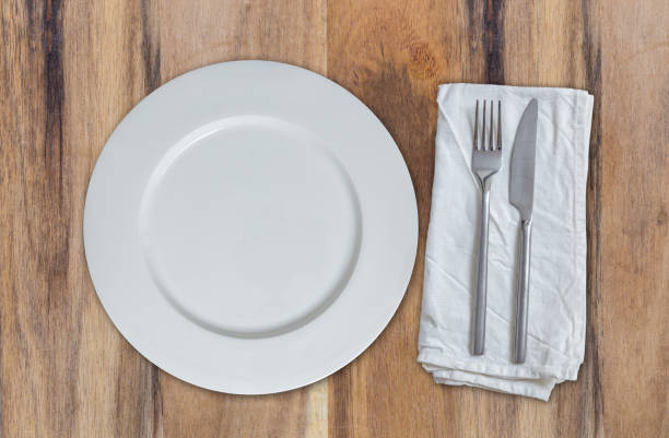 istock Empty plate with cutlery on acacia wood top view 810754206