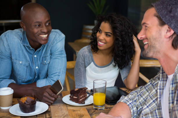 istock Friends talking at table in coffee house 810757094