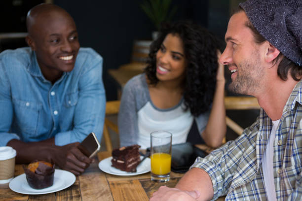 istock Man talking with friends at table in coffee house 810757240