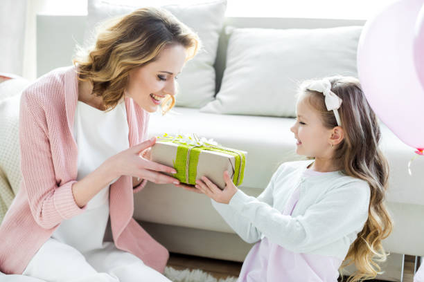 istock Girl presenting gift to mother 810773024