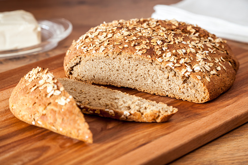 Delicious wheat-rye sourdough bread. Homemade whole grain bread sprinkled with oat flakes closeup