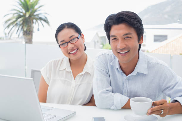 istock Smiling couple having breakfast together using laptop 810779392