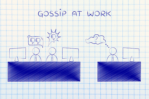 gossip at work: colleagues at office desk expressing negative opinions about a third person