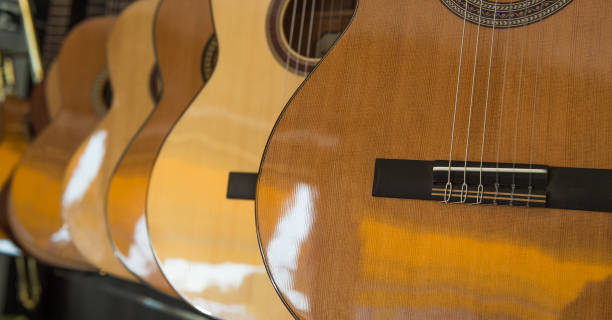 istock Many Classical Guitars Hanging on Wall in the Shop 810792058