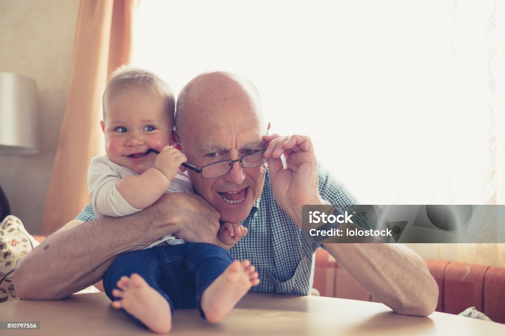 Grand-père jouer avec bébé à table - Photo de Bébé libre de droits