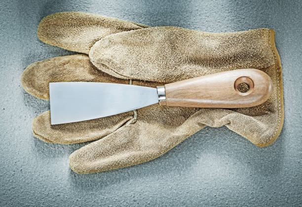 istock Palette knife leather protective gloves on concrete surface cons 810797572