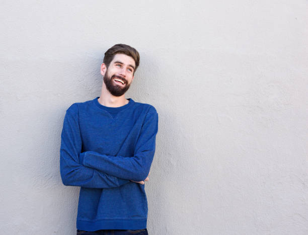 istock laughing man leaning on wall with arms crossed 810797860