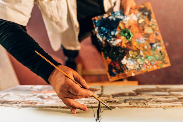 istock Old man artist painting oils in his studio. 810808168