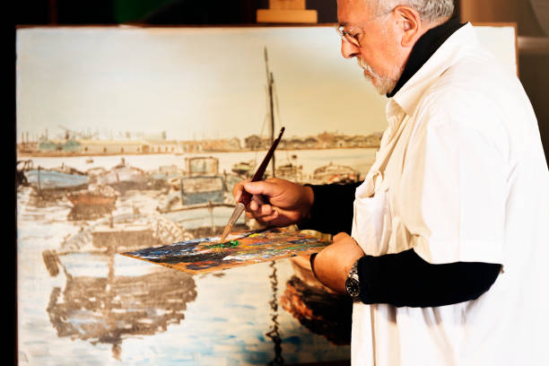 istock Old man artist painting oils in his studio. 810808198