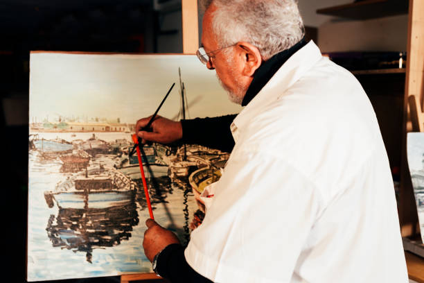 istock Old man artist painting oils in his studio. 810808218