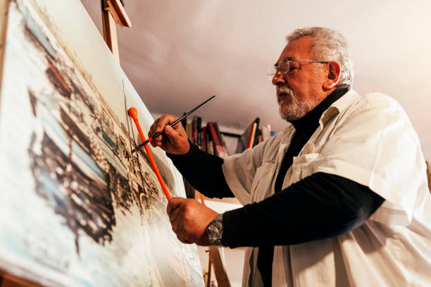 istock Old man artist painting oils in his studio. 810808320