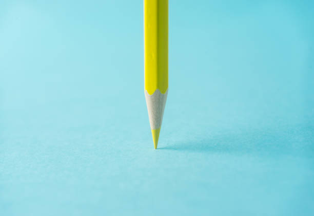 istock ne yellow color pencil stand on blue paper background 810833564