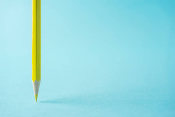 istock ne yellow color pencil stand on blue paper background 810834574