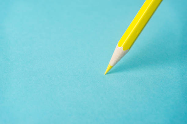 istock ne yellow color pencil stand on blue paper background 810836212
