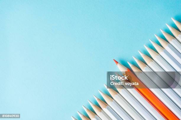 Lot Of White Pencils And Color Pencil On Blue Paper Background Stock Photo - Download Image Now