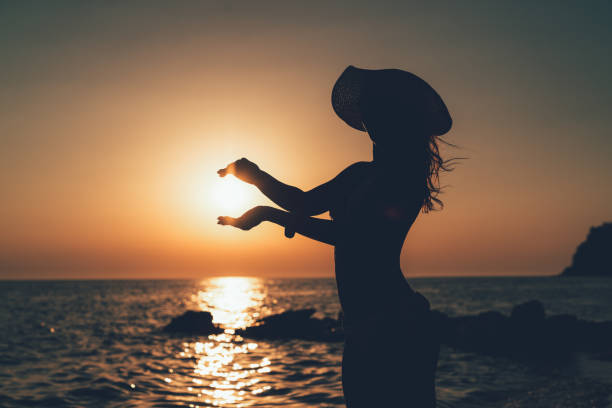istock Young Woman Holding Sun In Sunset 810850660