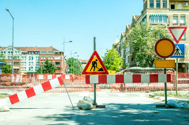 istock Work ahead construction site warning sign with barricades on the street. 810854296